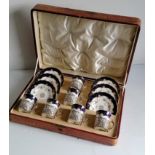A cased set of six Edwardian Coalport floral and gilt-edged coffee cans and saucer with pierced