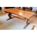 A hardwood Arts & Crafts-style refectory dining table with carved trestle supports, 75 x 200 x 79 cm