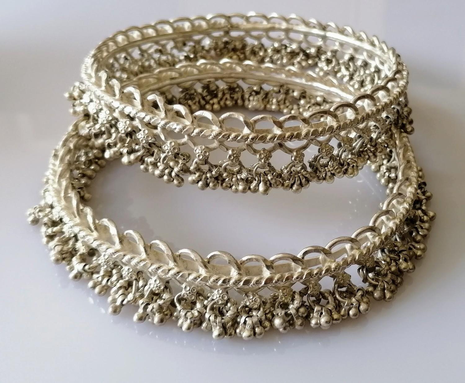 Two Indian silver anklets or bangles with tassels, each 10 cm diameter, 316g