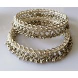 Two Indian silver anklets or bangles with tassels, each 10 cm diameter, 316g