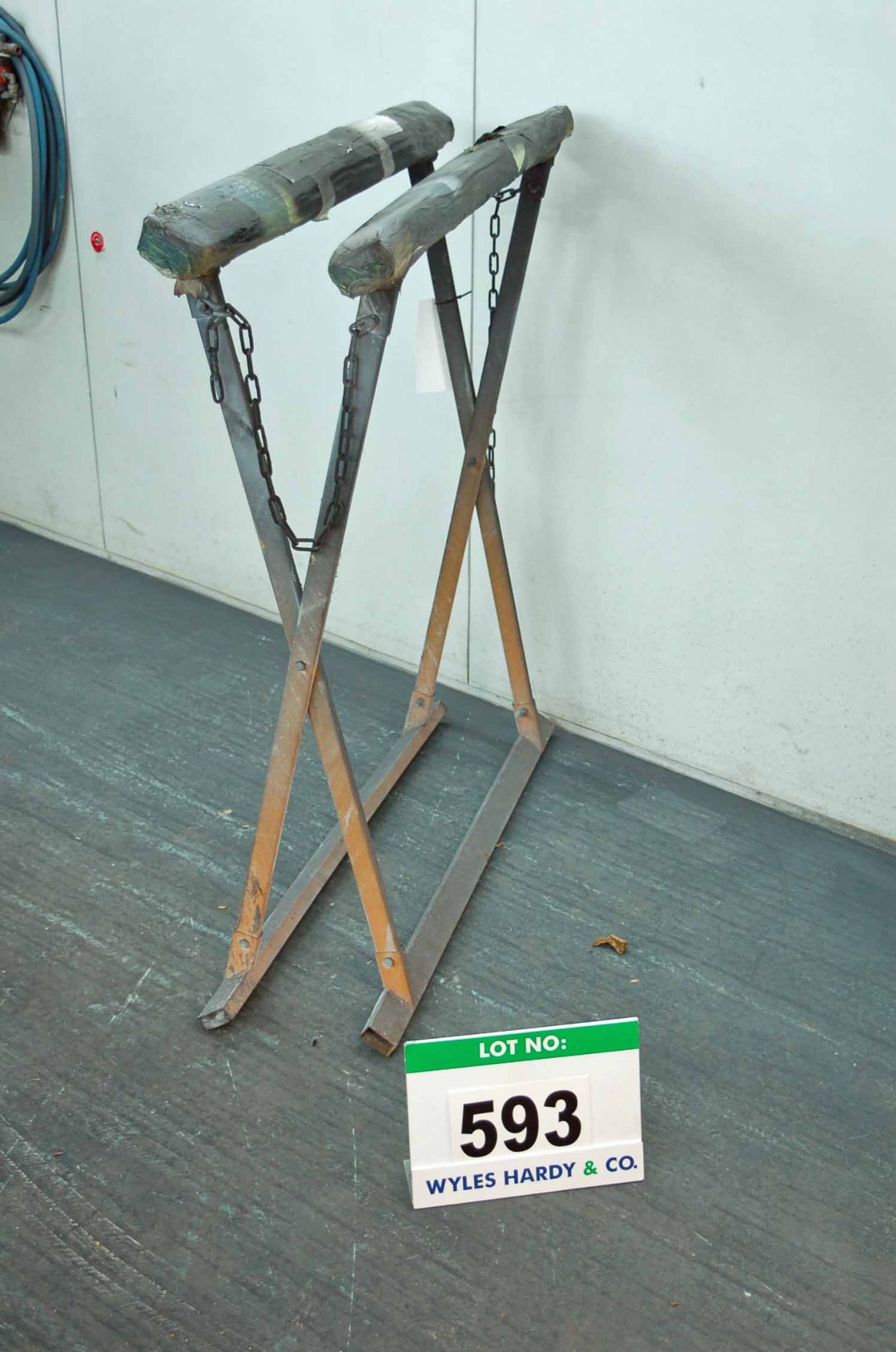 A Steel Framed Folding X Frame Panel Stand with Padded Tops and Chain Stays