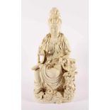 BLANC DE CHINE-FIGUR EINES SITZENDEN GUANYIN, Porzellan, auf einem wellenumspülten Felsen sitzend