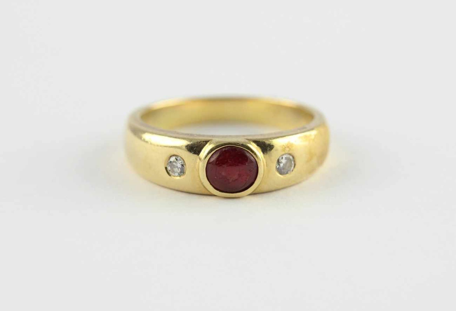 BANDRING, 750/ooo Gelbgold, besetzt mit einem Rubincabochon und zwei kleinen Diamanten, RG 57, 7,9g