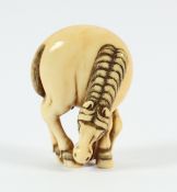 NETSUKE GROSSES GRASENDES PFERD, Elfenbein, die Beine eng zusammengestellt und mit wehendem Schweif,