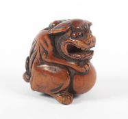 NETSUKE SHISHI AUF BALL, Buchsbaum, der sitzende Löwe mit geöffnetem Maul hält mit seinen