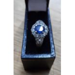 Fine quality, oval cut Sapphire surrounded by 18 round cut, high quality diamonds set in white