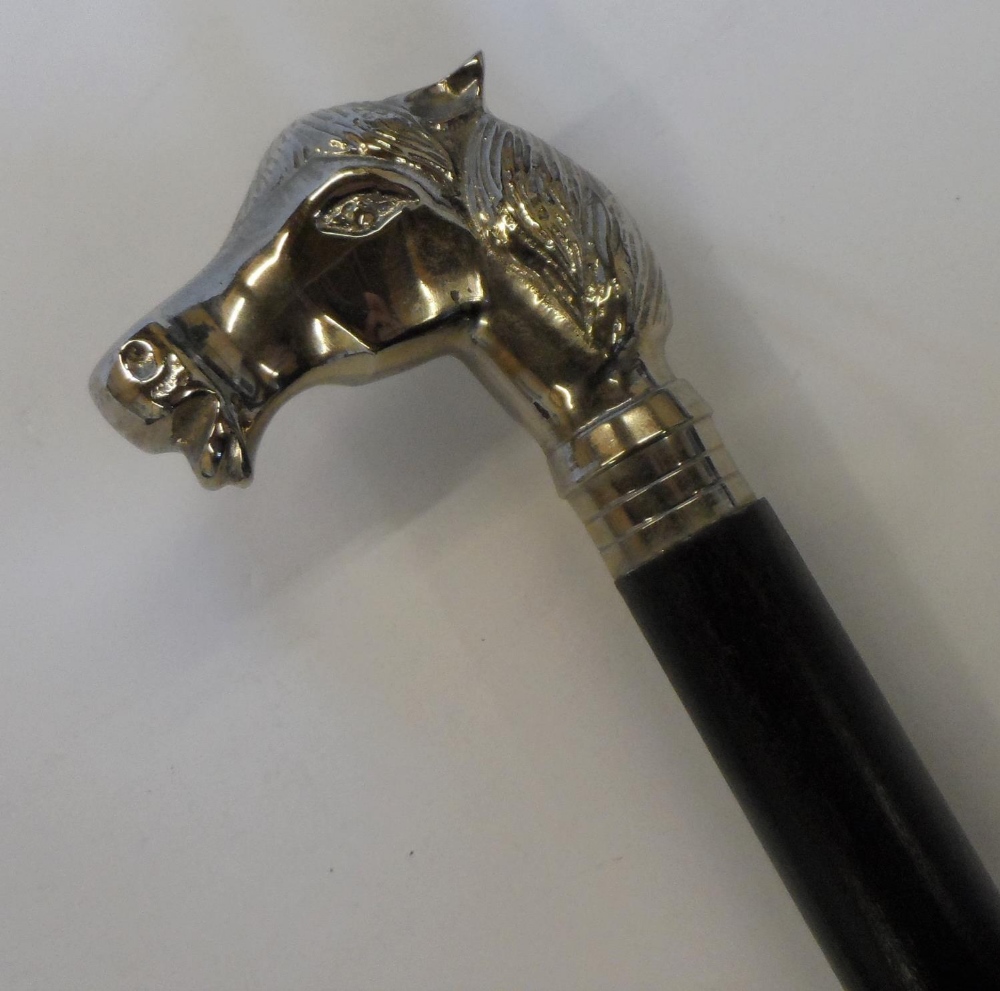 Unmarked, white metal horses head & ebonised wood walking stick with a white metal unmarked tip. The