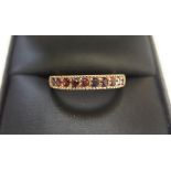 9ct yellow imported gold band ring set with 10 round cut natural garnets Approx 1.5 grams gross,