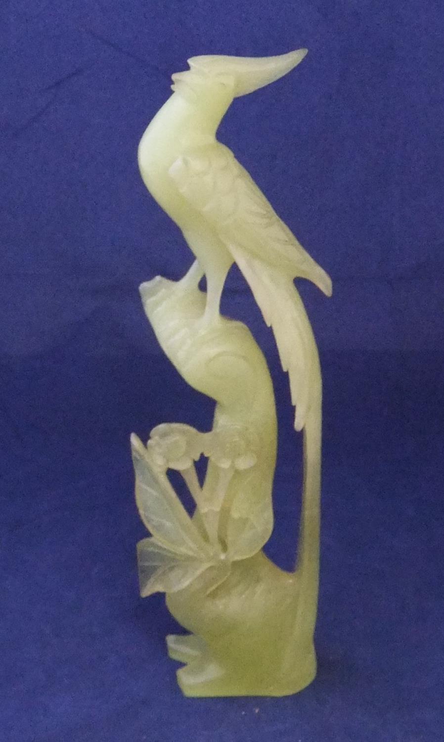 Finely carved jade statue of a bird amongst foliage 26cm high