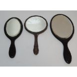 Silver backed hand mirror (330 grams gross) together with 2 similar ebonised wood examples (3)