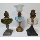 e Victorian metal based oil lamps & 1 milk glass shade (4) All approx 32 cm tall No flutes