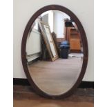 Antique bevelled edge oval mirror with inlaid wooden frame,