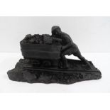 Made from British coal is this figure of a Man pushing a small coal cart,