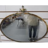 Mid 20thC large oval bevelled edged mirror with brass mount, 47 x 72 cm