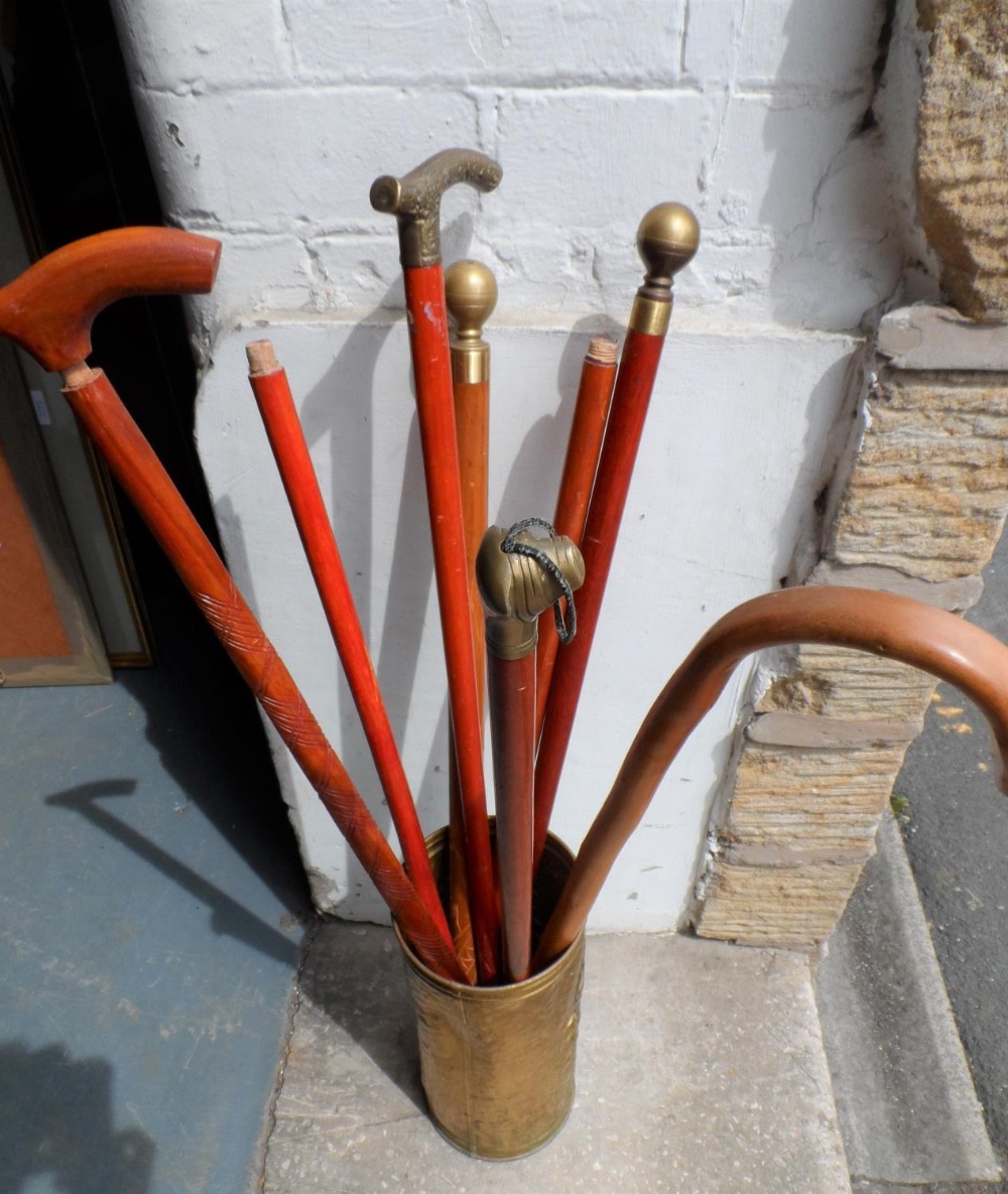 Collection of mainly brass topped walking sticks in brass holder (Qty)