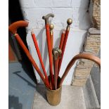 Collection of mainly brass topped walking sticks in brass holder (Qty)