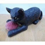 Bretby pottery model of a cat with glass eyes holding a reel of wool in its forelegs, 24cm long,