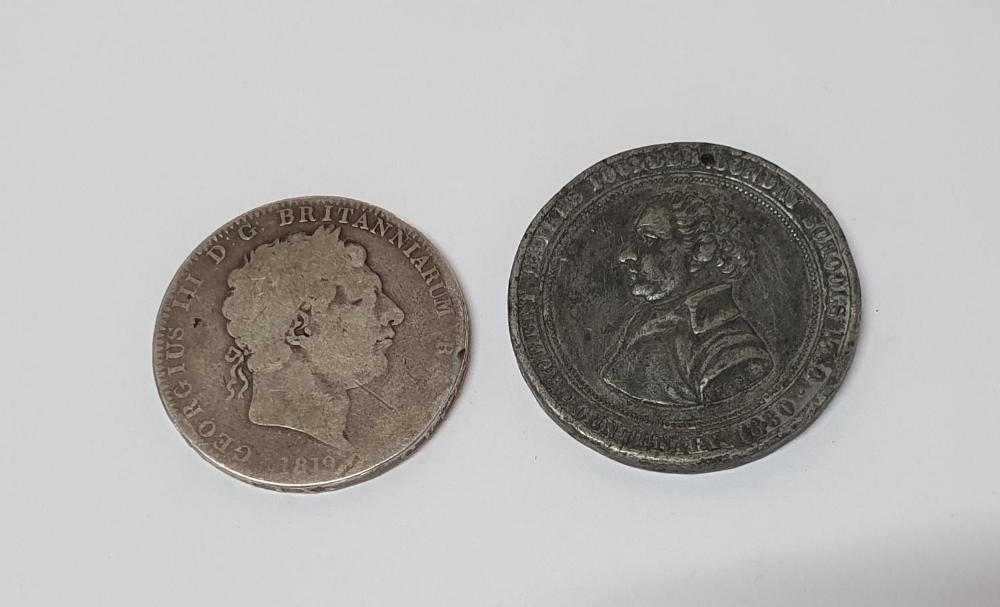 George III 1819 silver crown together with a 19thC base metal, drilled, foreign coin or medal (2)