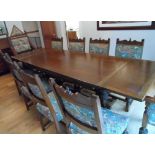 Large 20thC stained oak dining table with drop leaf ends together with 10 matching chairs