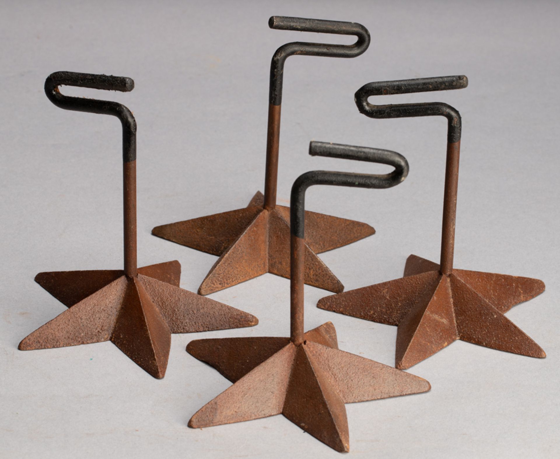 Group of four iron Pistol Stands on five point star cast iron bases. WILL BE SOLD AS ONE . KING COLL