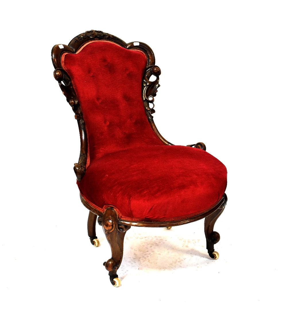 A Victorian stained walnut nursing chair upholstered in red button-back velvet,