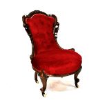 A Victorian stained walnut nursing chair upholstered in red button-back velvet,