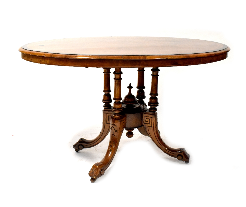 A Victorian walnut oval tilt-top dining table with inlay,