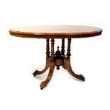 A Victorian walnut oval tilt-top dining table with inlay,