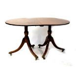A Regency-style mahogany D-end twin pedestal dining table with one extra leaf,