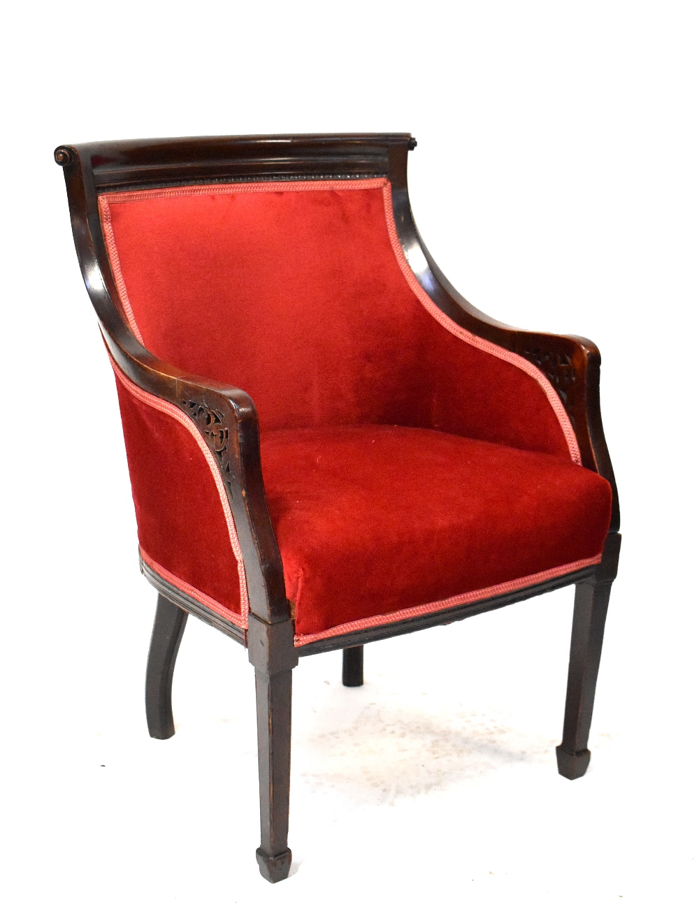 An Edwardian mahogany tub armchair with scroll top rail and overstuffed seat and back upholstered