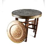 A 19th century circular Indian metal ornate table on a collapsible mother of pearl inlaid hardwood