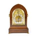 A c1890 inlaid mahogany lancet bracket clock, the gilded dial with raised decoration,