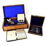 An oak cutlery box with carved Oriental junk to the centre and a small quantity of cased plated