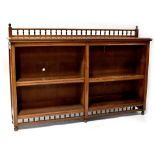 A late Victorian walnut freestanding bookcase with bobbin turned gallery above two sections,