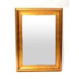 A reproduction gilt-framed mirror,