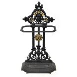 A painted and gilt-heightened cast iron stick stand with Green Man motif and drop-in drip tray,