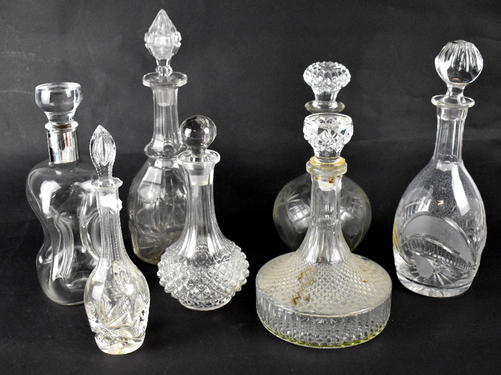 Seven 19th and 20th century glass decanters to include a Cluck-Cluck example with white metal