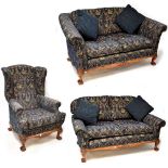 A walnut-framed three-piece suite comprising a wing armchair and two two-seater settees,