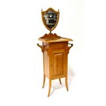 An Edwardian tile-top wash stand with shield-shaped mirror above a base of single cupboard door