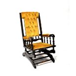 A 19th century American ebonised rocking chair with button-back mustard-coloured velour upholstery.