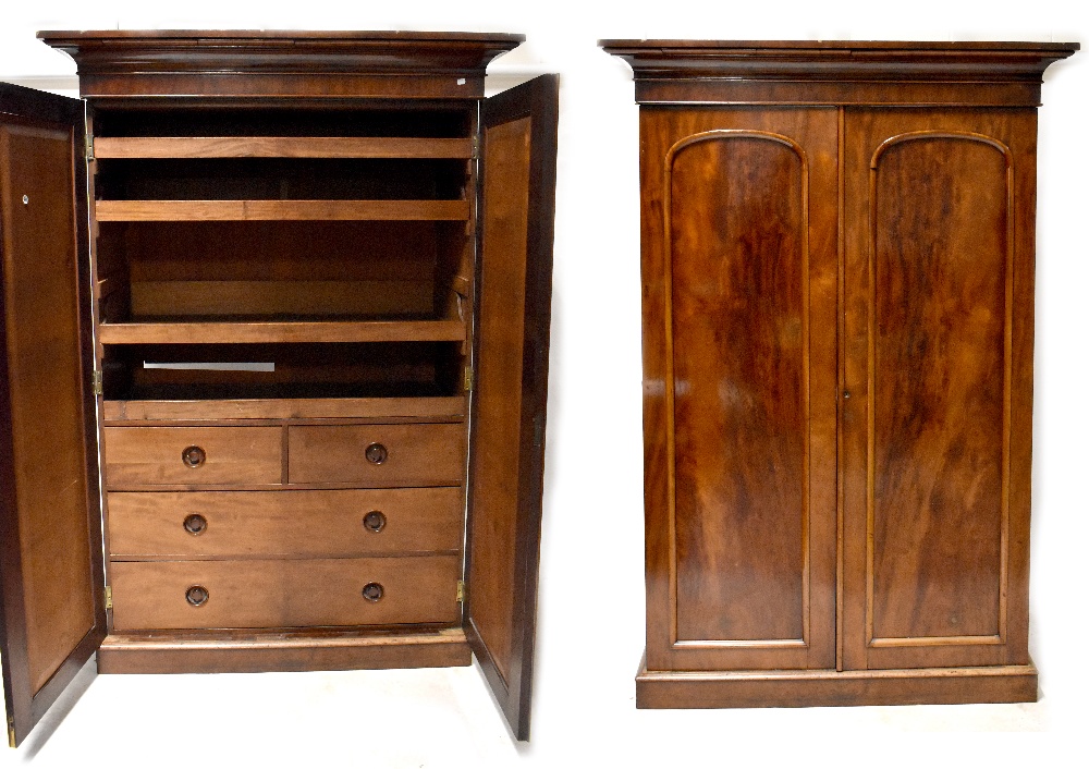 A Victorian mahogany linen press, two doors with arched raised panels,