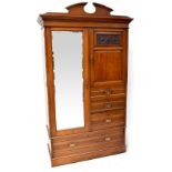 An Edwardian walnut compactum wardrobe with single mirrored drawer flanked by a carved and panelled