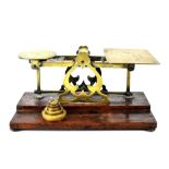 A 19th century brass letter/book post scale on a stepped mahogany base with five weights.