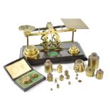 A set of late 19th/early 20th century brass inland postal letter scales on rectangular mahogany