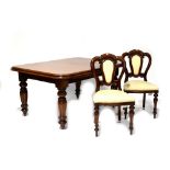 A 20th century reproduction mahogany wind-out dining table to fluted baluster supports and peg feet,