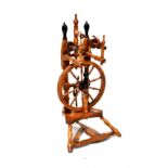 An oak and fruitwood spinning wheel with ebonised handles and ivorine terminals, height 85cm (af).