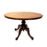 A Victorian inlaid walnut oval tilt-top table on central turned column to cabriole legs,