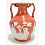 A 19th century twin handled replica of a Wedgwood Portland vase, relief decorated with Grecian