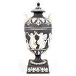 WEDGWOOD; a black and white jasper dip urn and cover with twin pierced mask loop handles above a