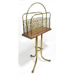 An Edwardian oak and brass swivel action magazine rack with central raised loop above mesh side